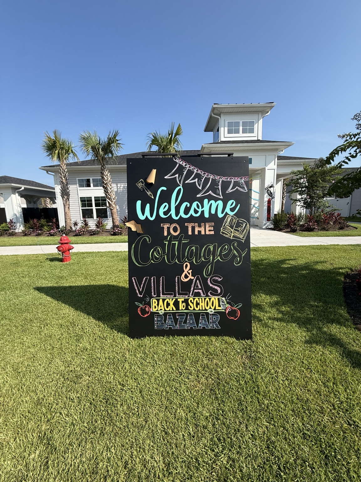 Hand-drawn Back-to-School Bazaar welcome sign at the two-community event produced by Rebecca Stephen