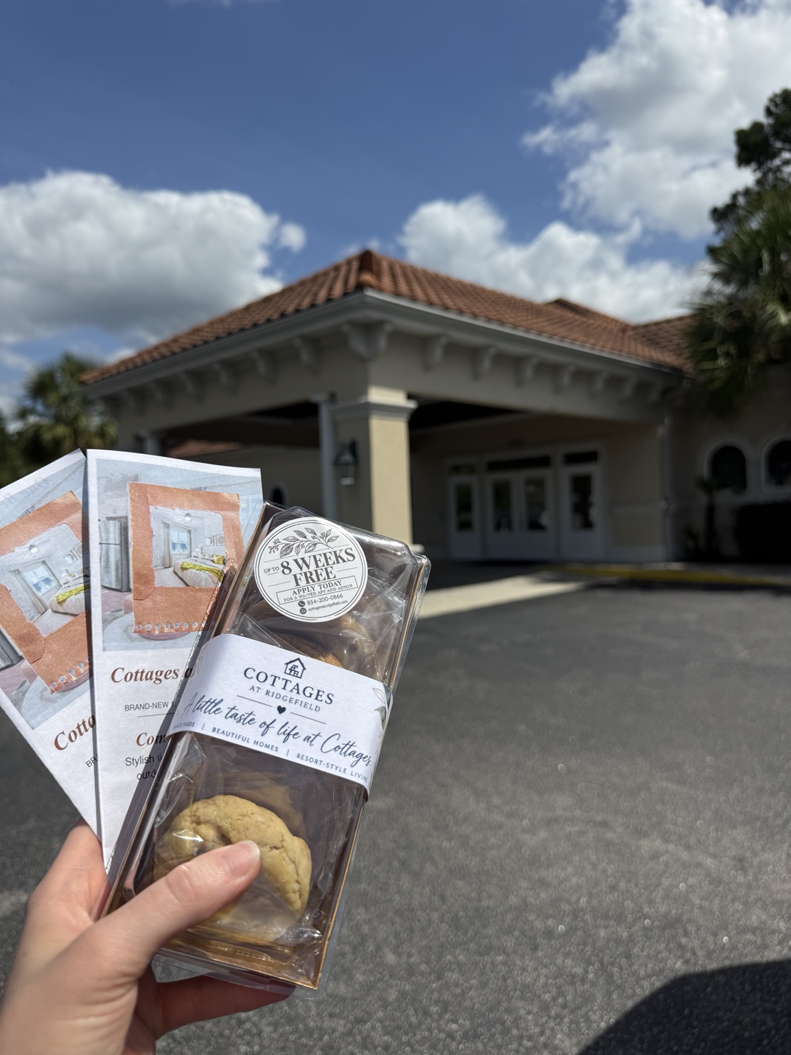 A completed Cottages at Ridgefield cookie box and leasing flyers being carried to a local outreach visit
