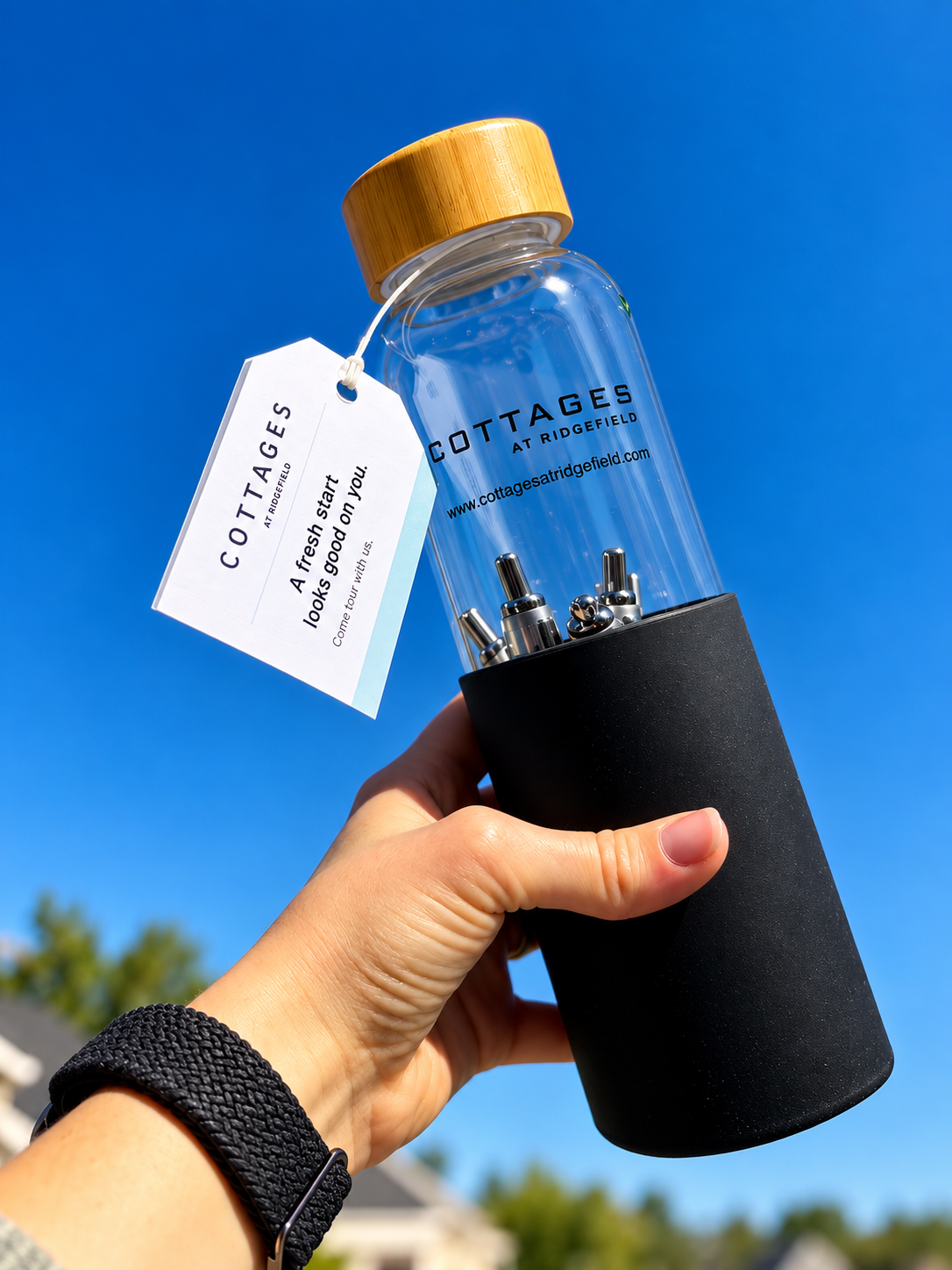 Final edited photograph showing the branded Cottages at Ridgefield bottle and its in-house-produced tag against the sky