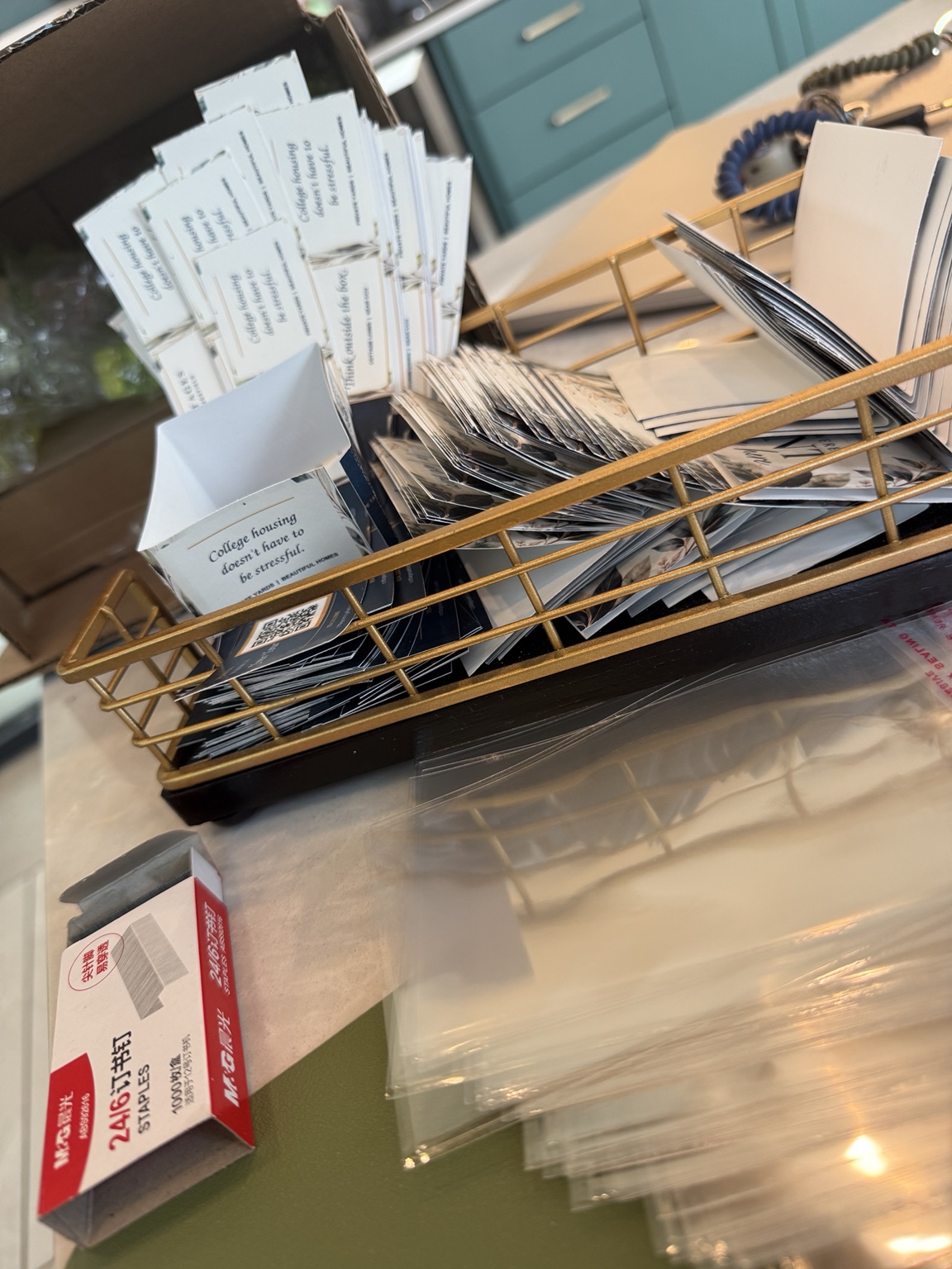 Rebecca Stephen seated on the floor hand-assembling resident invitations for delivery throughout the community